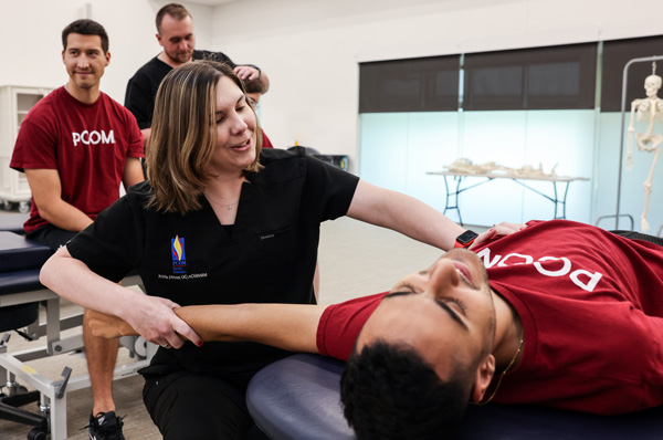 Osteopathic medicine professors demonstrate OMM techniques in a PCOM classroom