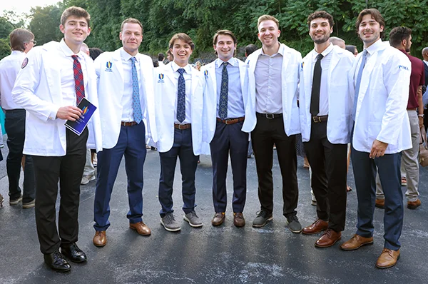 A group of PCOM DO students smile during a campus event