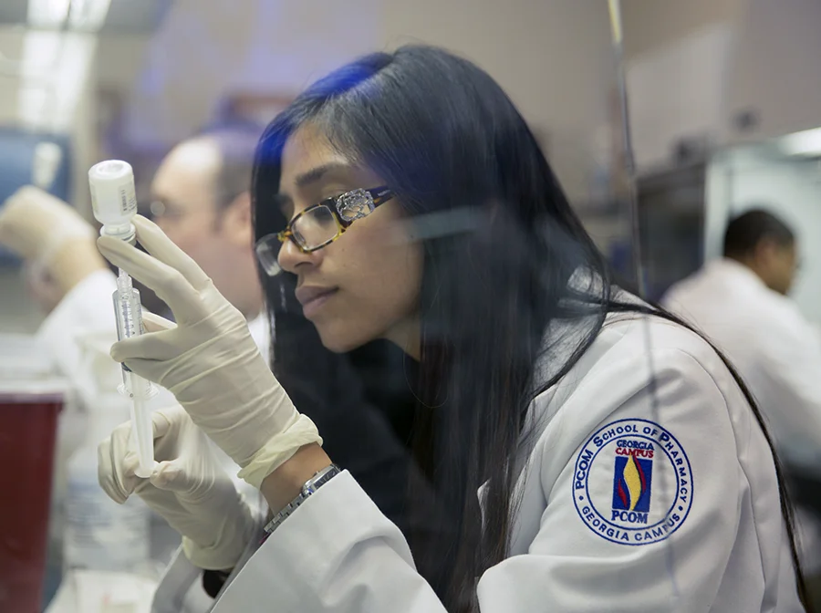A PCOM Georgia doctor of pharmacy student handles equipment during a lab exercise