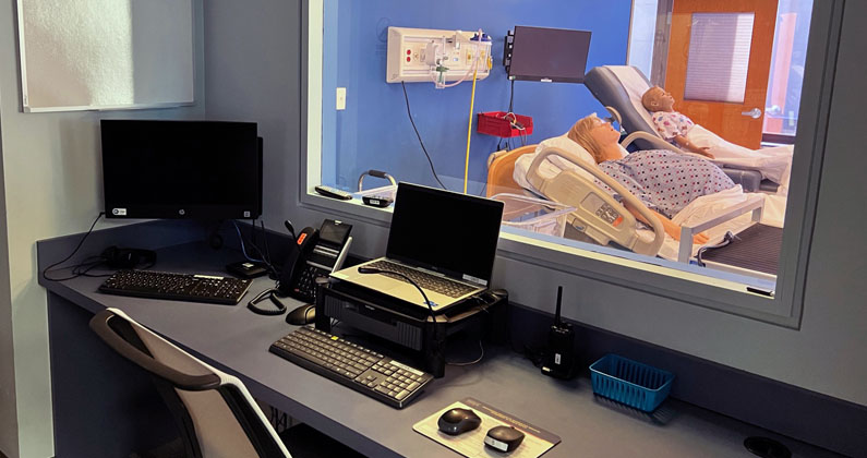 Sim center control room with monitors, computers, keyboards and other equipment