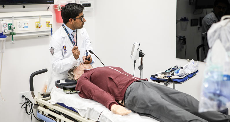 Student working on an adult patient mannequin in the PCOM South Georgia Simulation Center