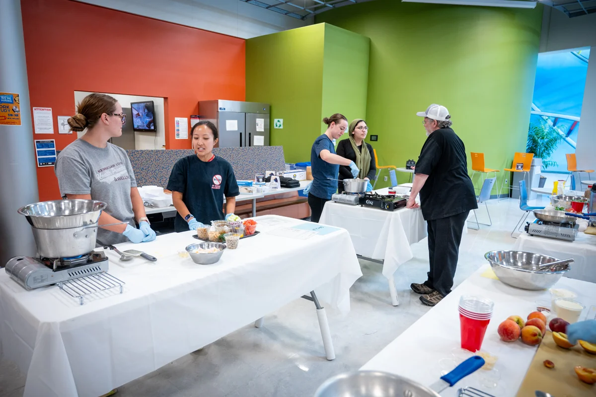Students and staff talking during a cooking event in the Atrium at PCOM Georgia