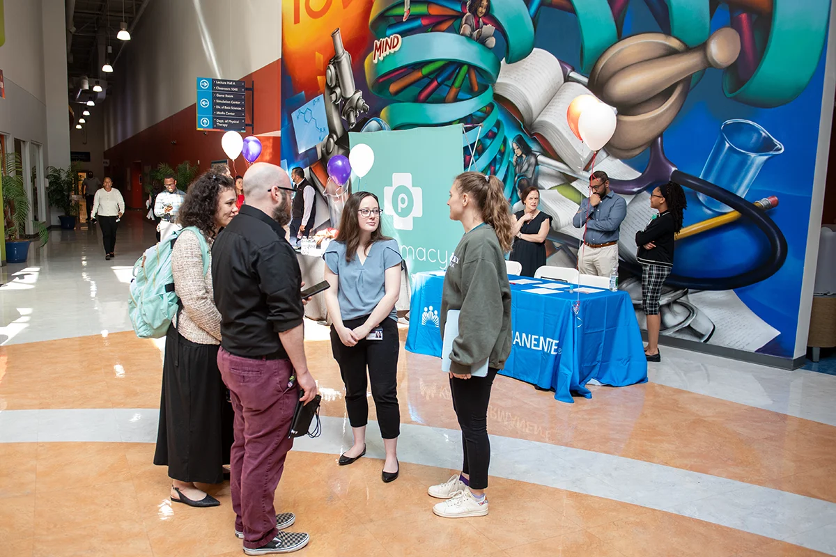 Students and staff talking in the PCOM Georgia atrium during an event