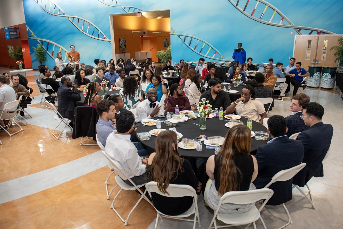 People sitting around tables during a dinner event in the Atrium