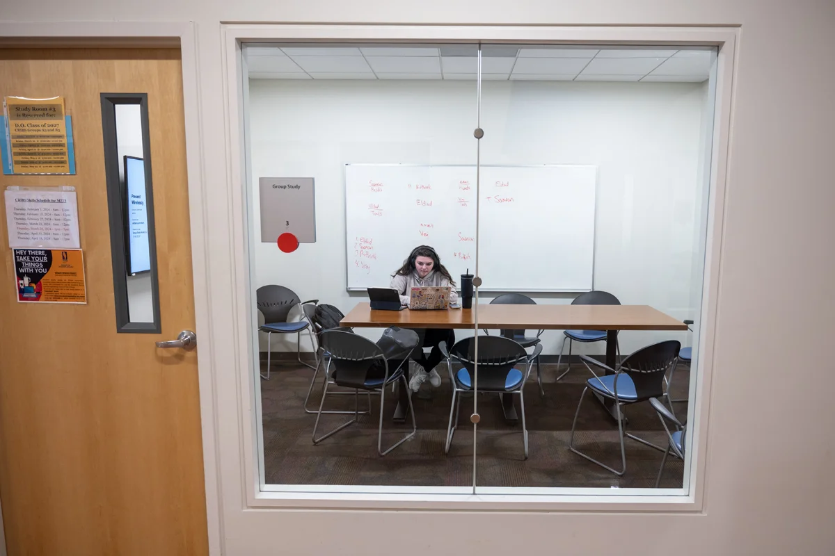 Student using a laptop in a study room in PCOM Georgia