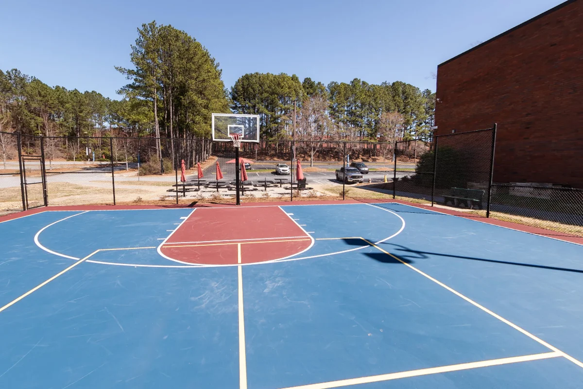 View of the outdoor sports court and fencing toward the parking lot