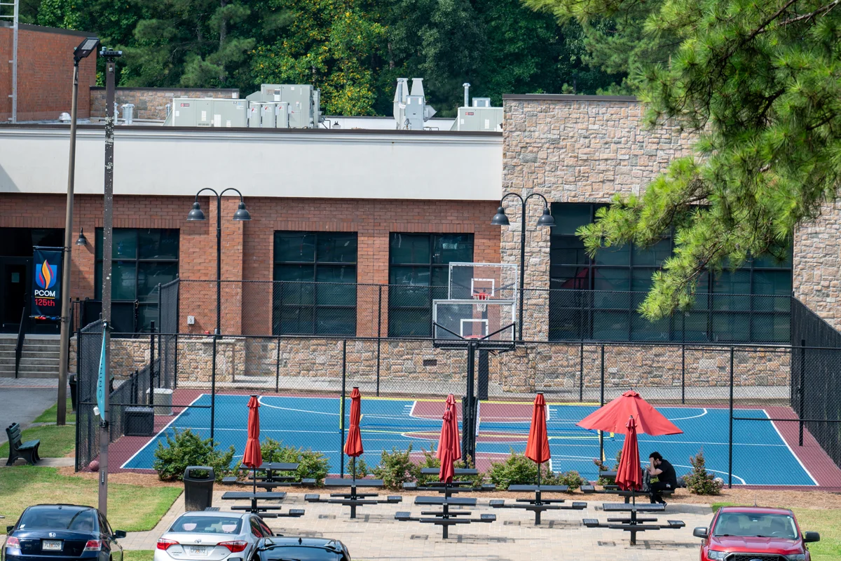 Wide view of the outdoor sports court and picnic table area at PCOM Georgia's campus in Suwanee