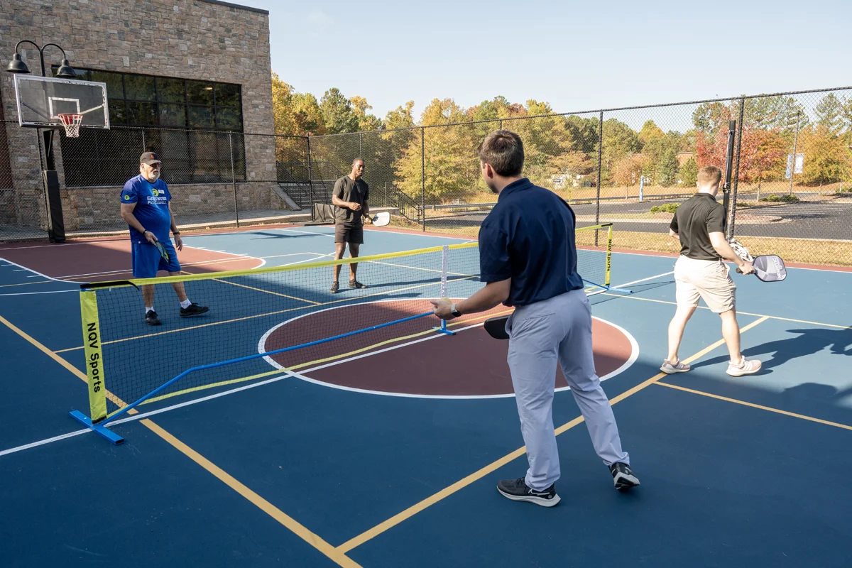 Students and staff playing pickleball on the outdoor sports court