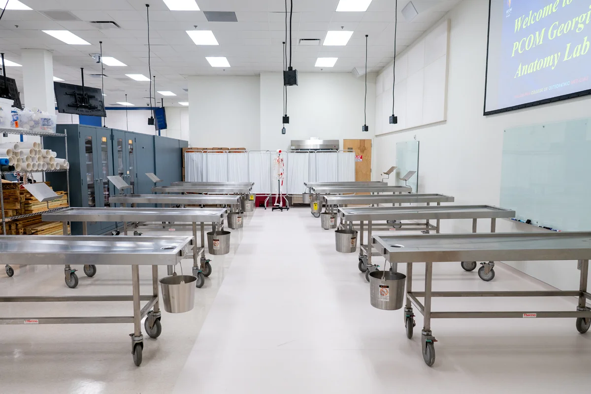 The physical therapy section of the PCOM Georgia Anatomy Laboratory contains dissection tables, shelves, projector screens and other learning tools
