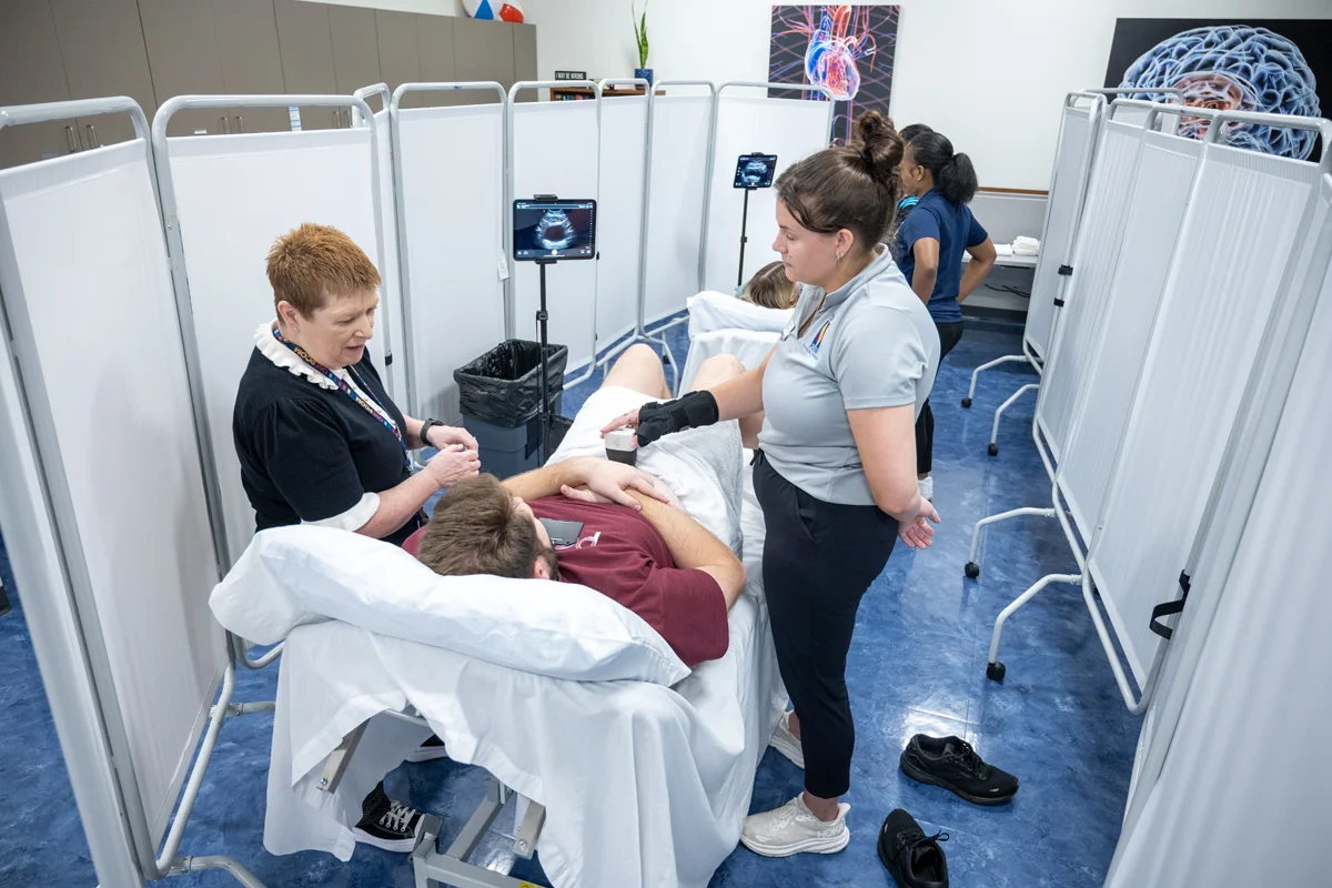 DPT students and faculty smile during a pelvic exam learning exercise