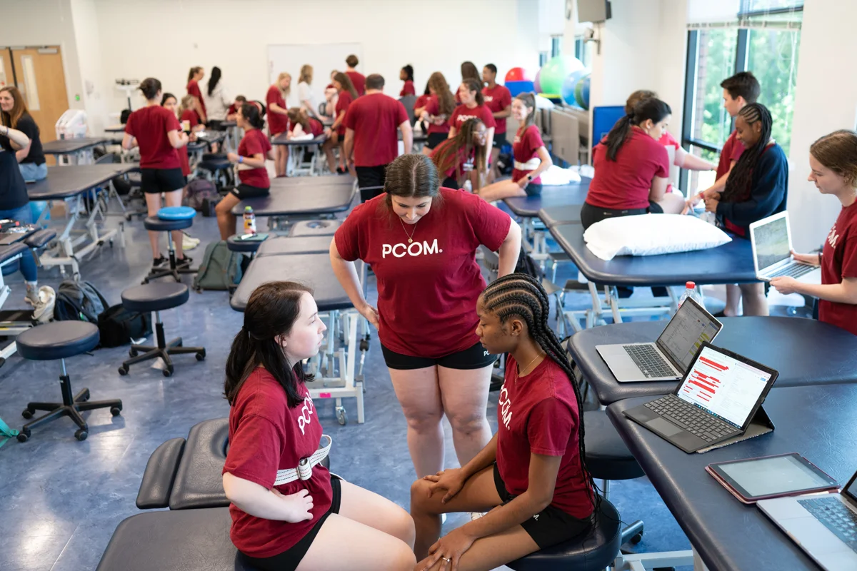 Physical therapy students smile and engage in a hands-on learning activity in the DPT classroom
