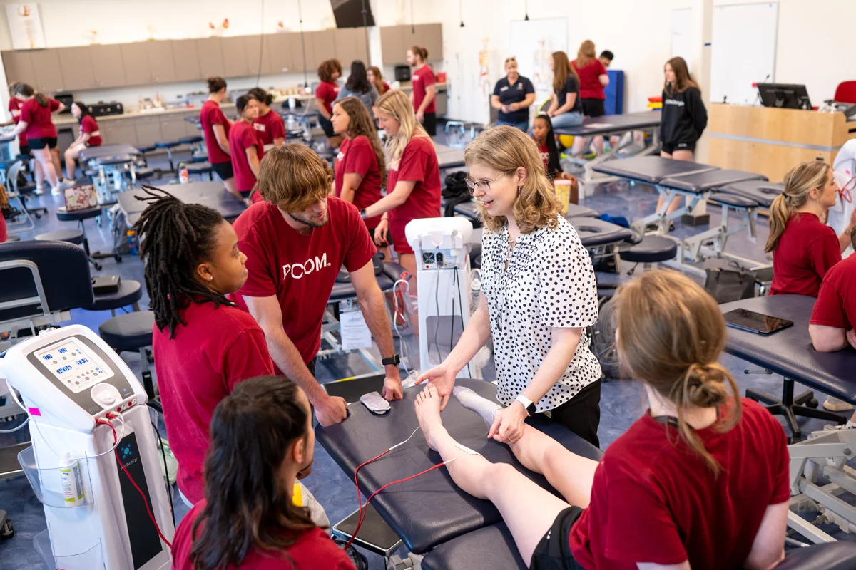 DPT students and faculty smile during an exercise in a lab