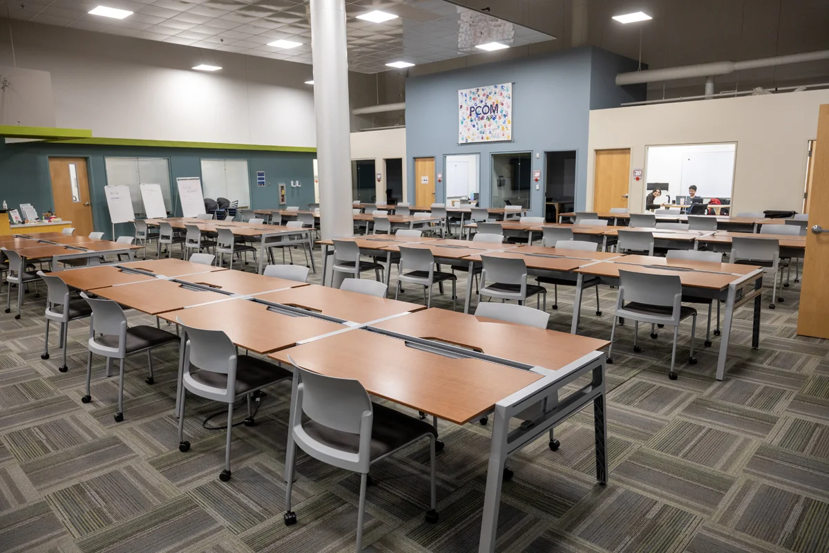 Wide view of PCOM Georgia's Information Commons including desks, chairs and bookshelves