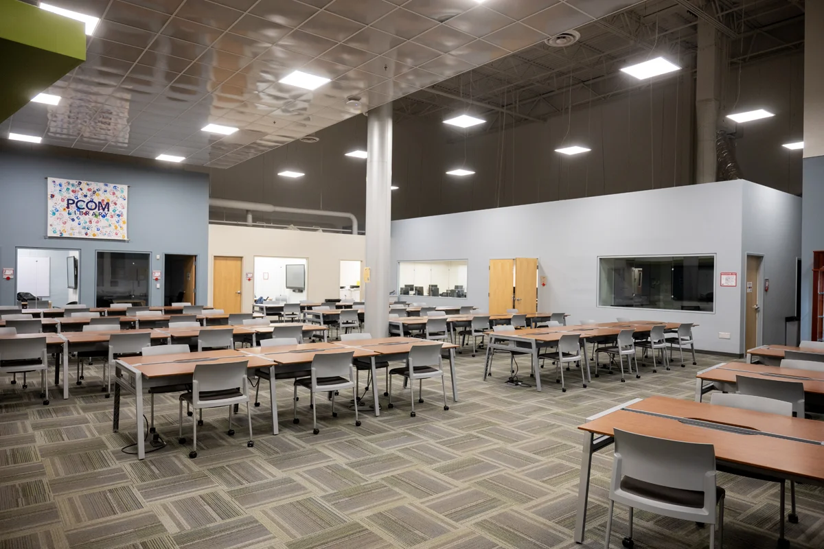 Wide view of PCOM Georgia's Information Commons including desks, chairs and bookshelves