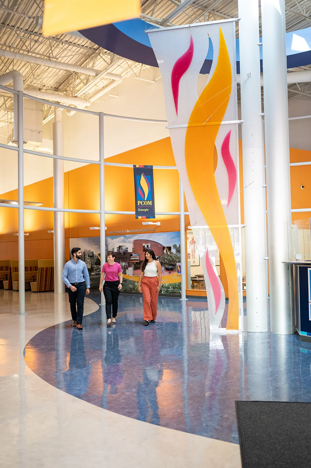 PCOM Georgia faculty and students smile and walk through the main lobby