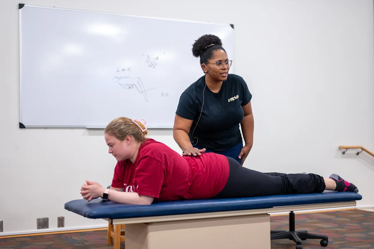 A PCOM Georgia OMM faculty members highlights an OMM technique in front of the class