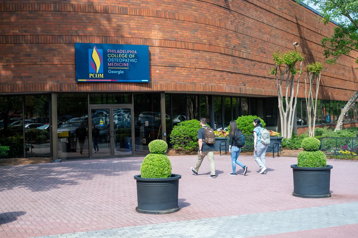 Photo of students walking into the Old Peachtree building's main front doors