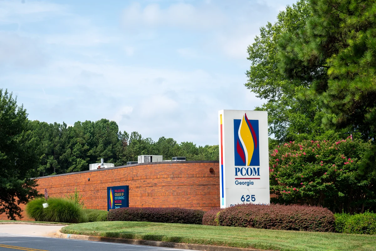 A large PCOM Georgia campus building sign from Old Peachtree Road