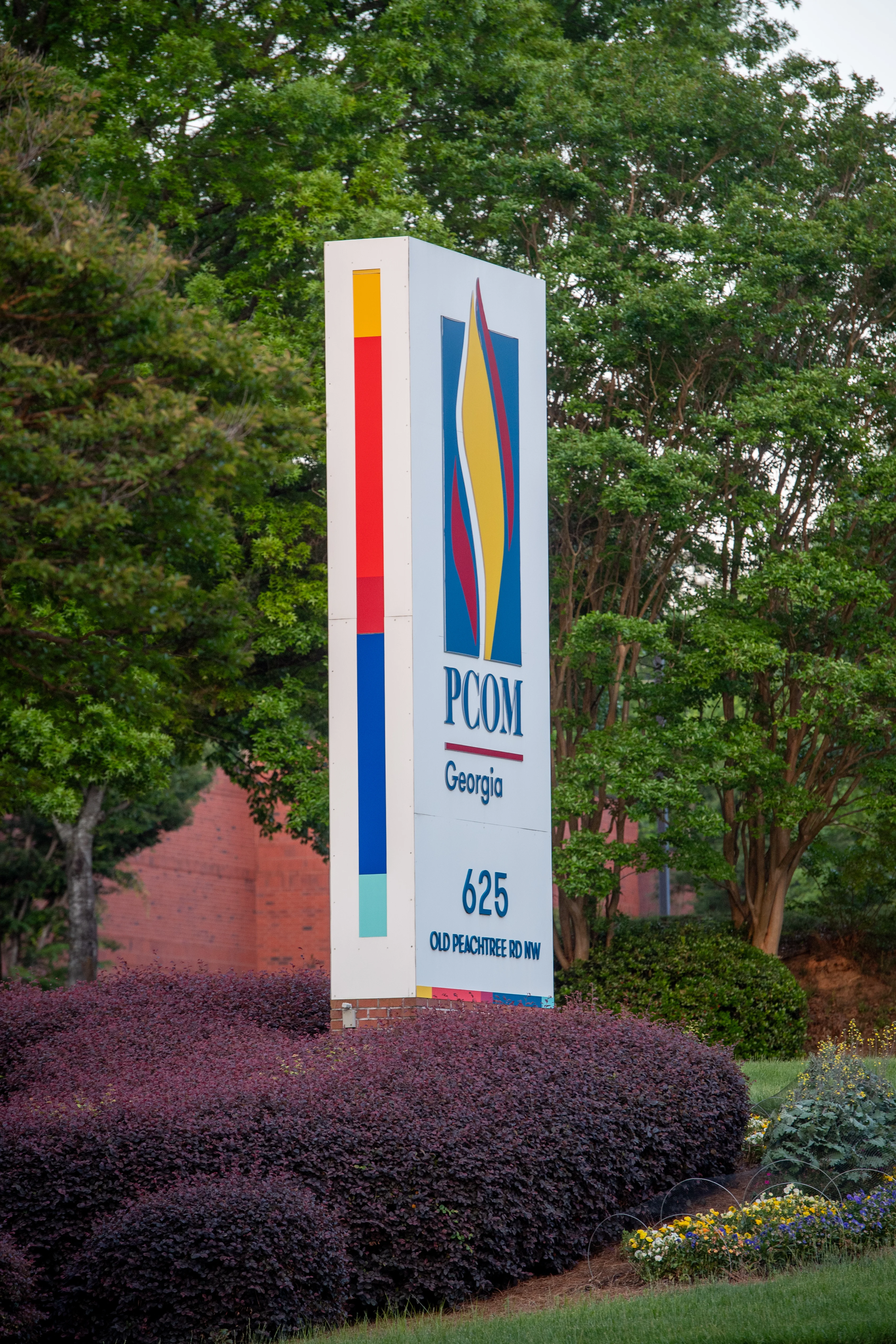 Vertical shot of the PCOM Georgia campus sign on the side of the main road