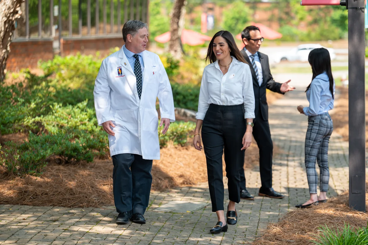 Pharmacy students and faculty smiling and talking during a campus tour