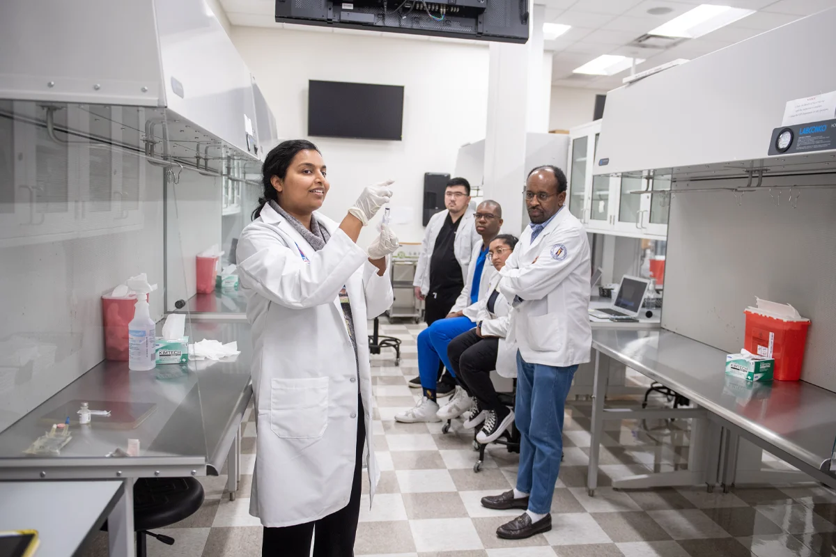 A PharmD faculty member demonstrates in the sterile products pab