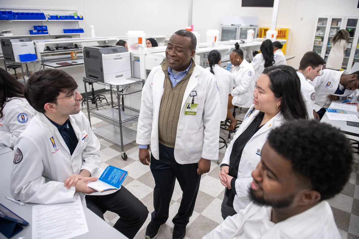 PCOM Georgia pharmacy students and faculty smiling and talking during a lab exercise
