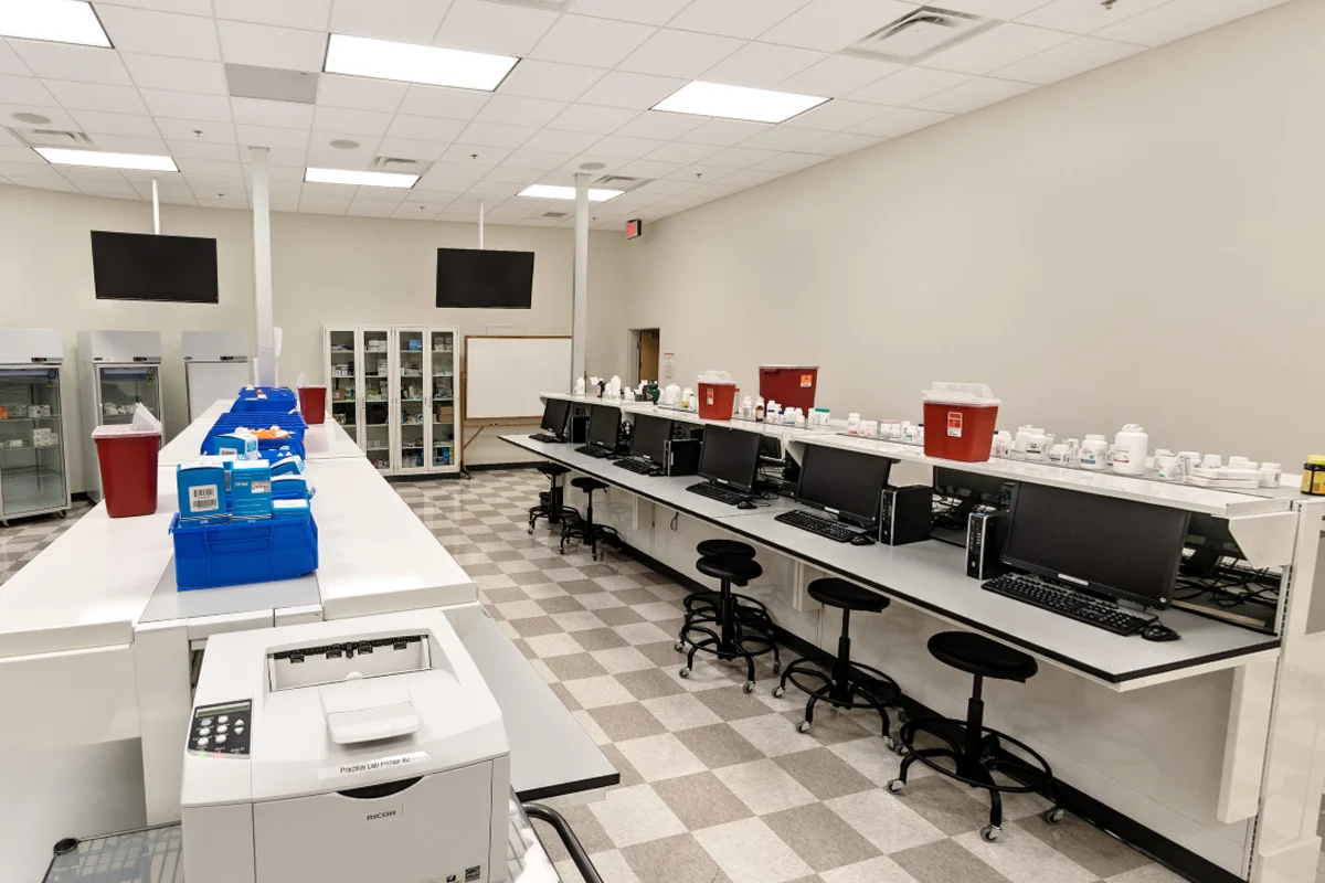 Wide view of the tables and equipment in the pharmacy practice lab