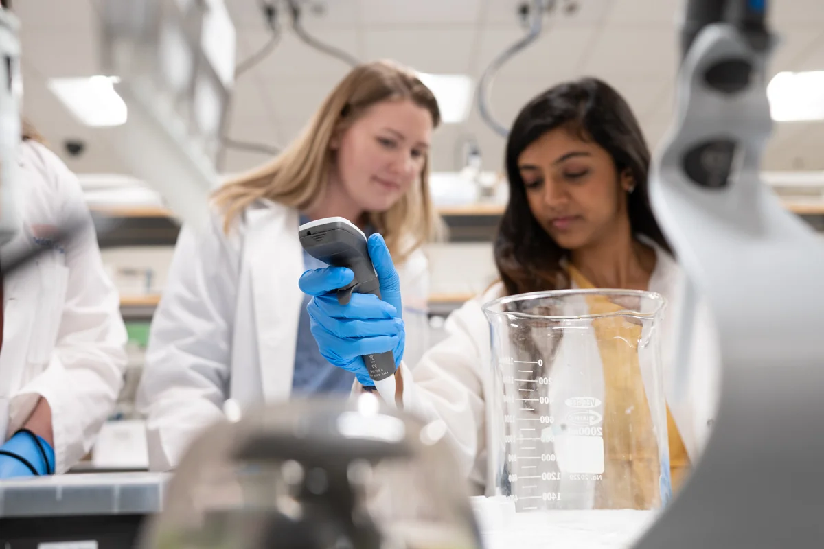 PCOM Georgia students smile while conducting research in a laboratory
