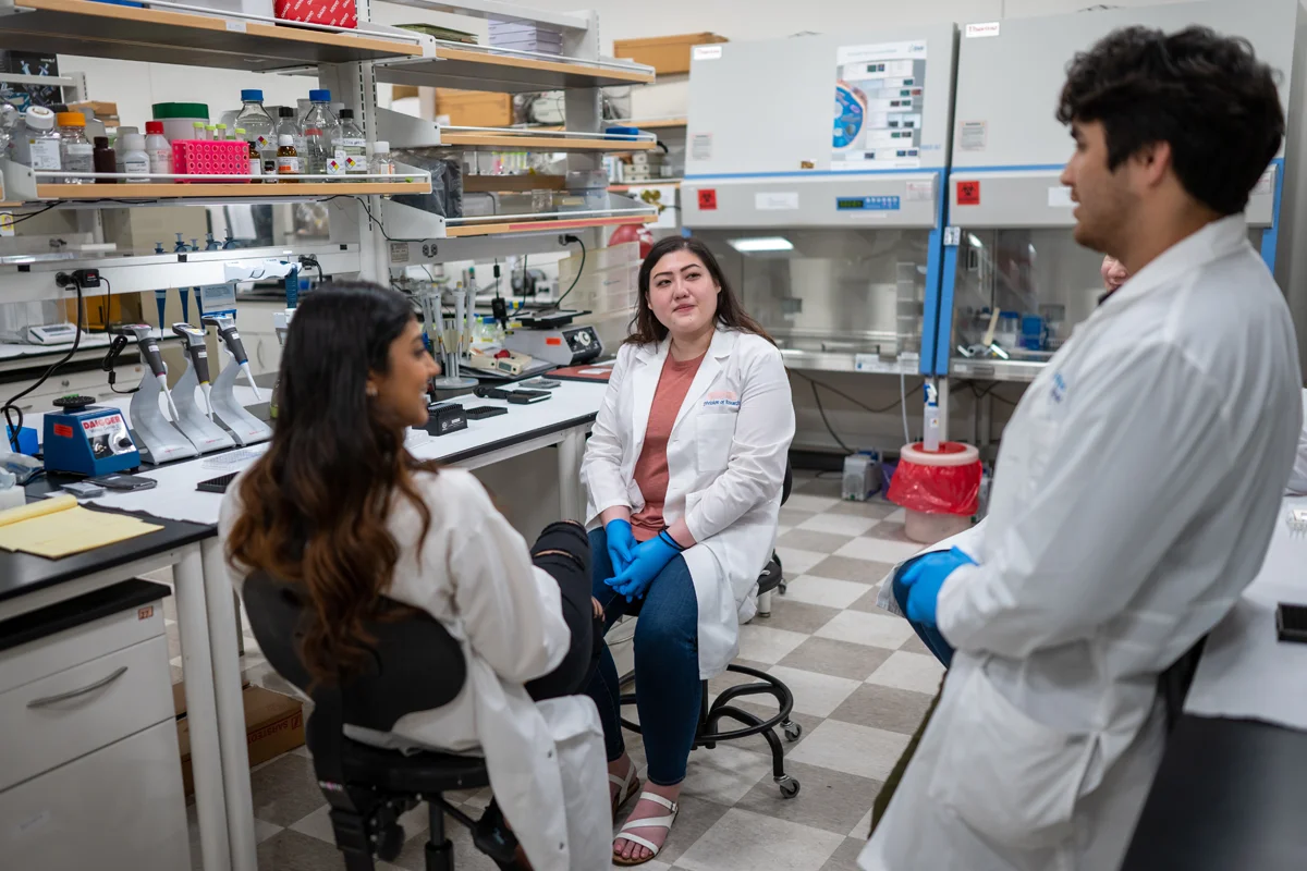 PCOM Georgia research students smile and talk in a lab