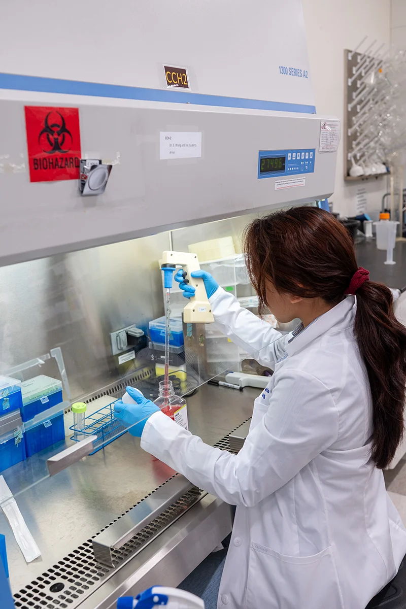 Vertical photo of a student using a station in a research lab at PCOM Georgia