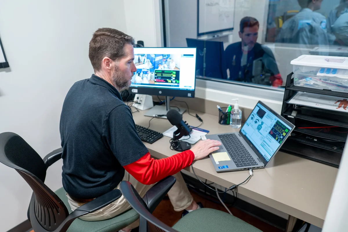 PCOM staff member uses monitoring equipment in the Simulation Center