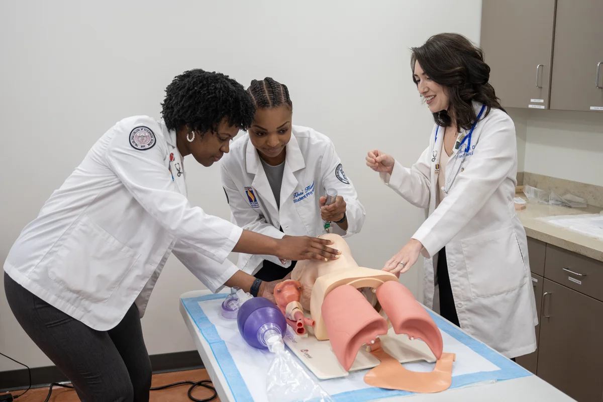 PCOM faculty member shows med students how to handle medical equipment in an exam room