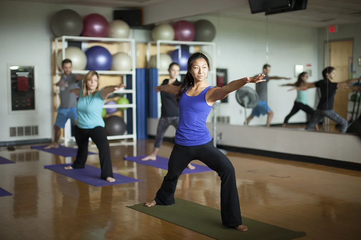 Students and staff participating in a yoga class in the PCOM Activities Center studio room