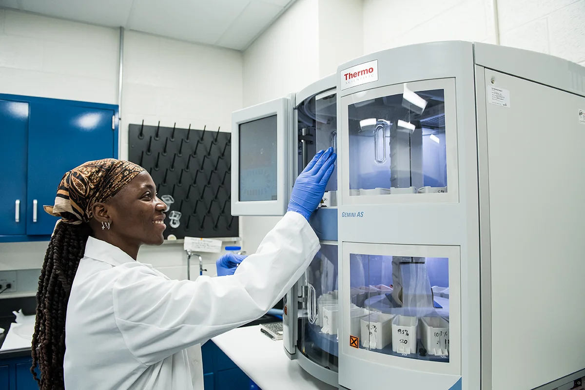 A female student smiles as she handles equipment in the bioimaging lab