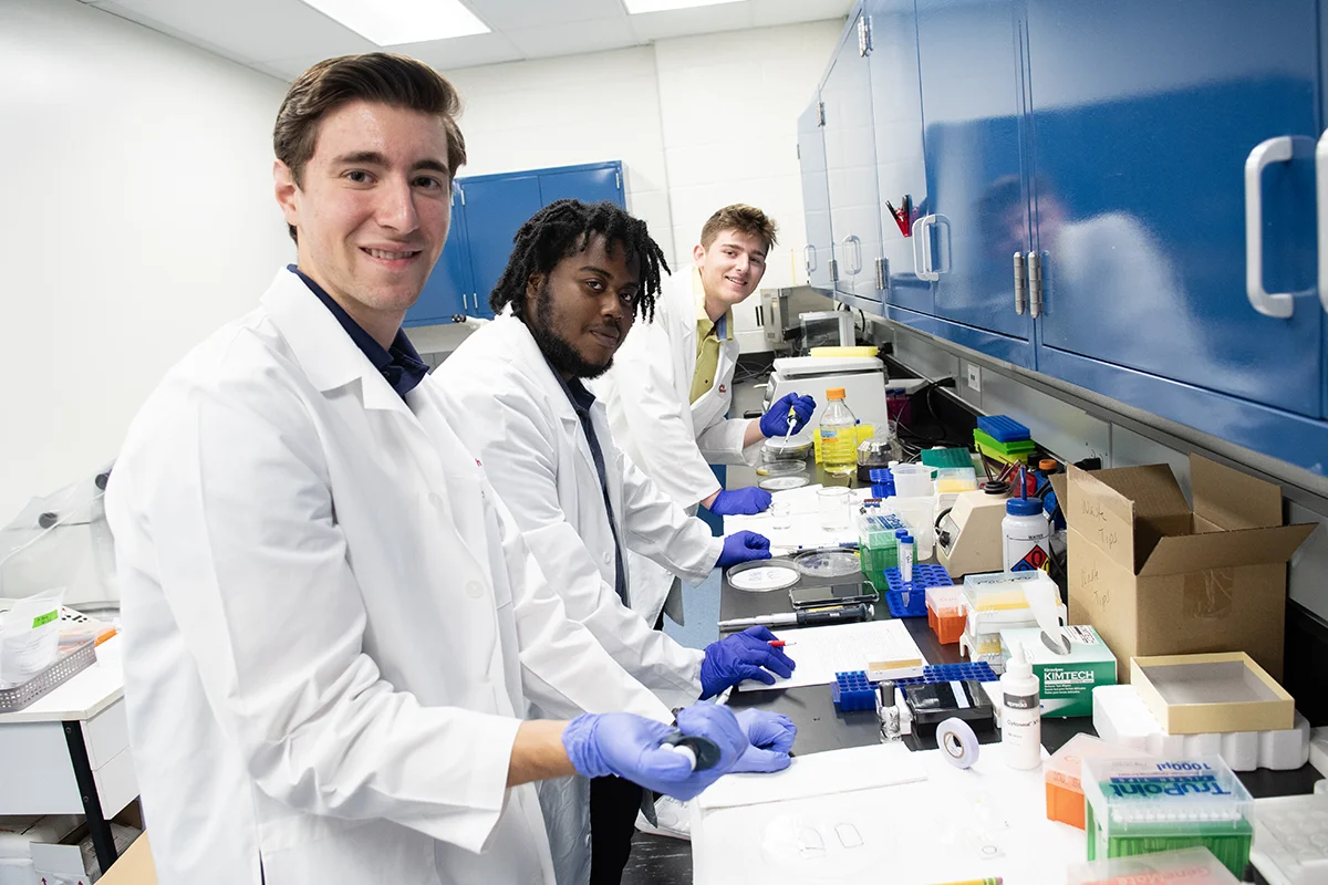 Students smiling as they work along a countertop in the bioimaging lab