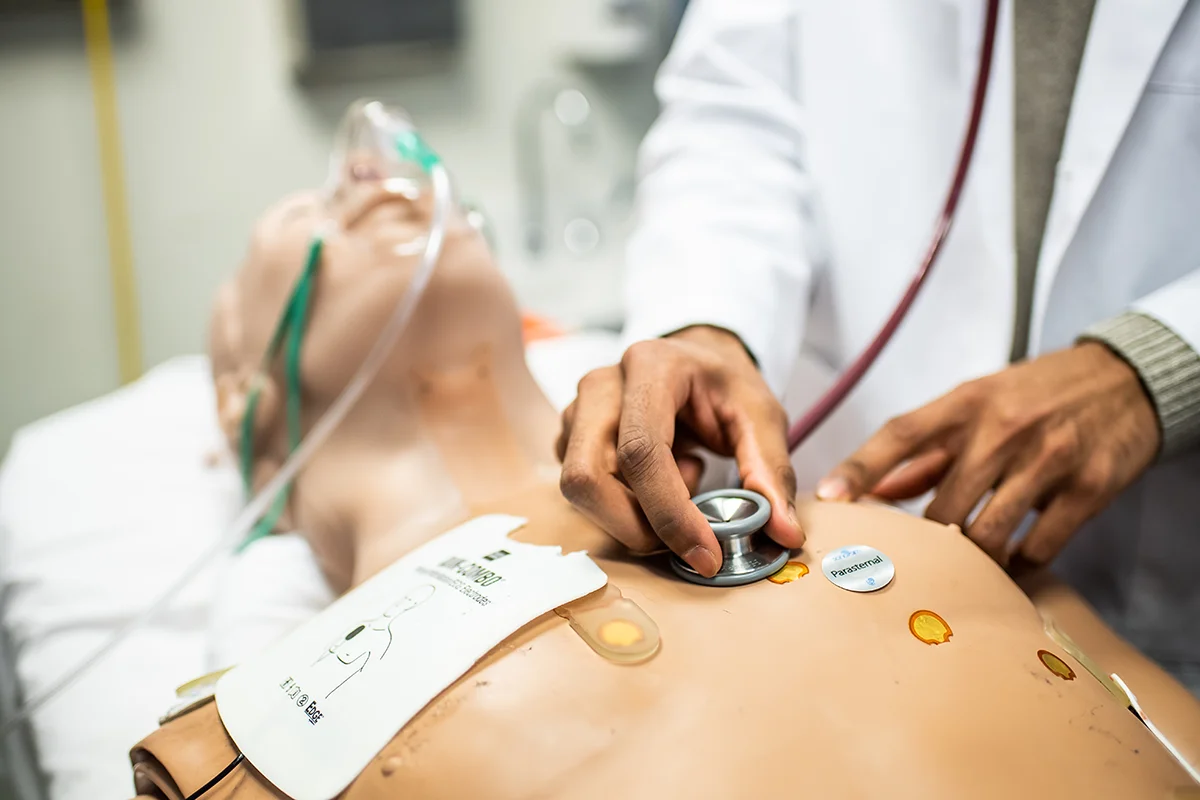 Macro shot of a student using a stethoscope on a patient mannequin