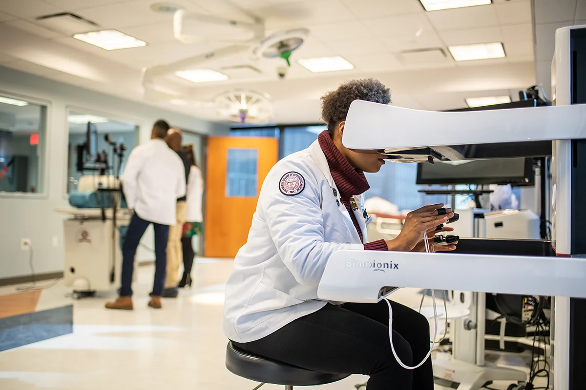 Med student concentrating as she uses surgery simulation equipment in the PCOM CLAC