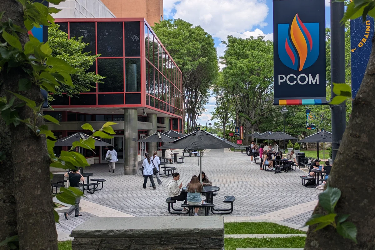Students sitting and studying around circular picnic tables in the central courtyard