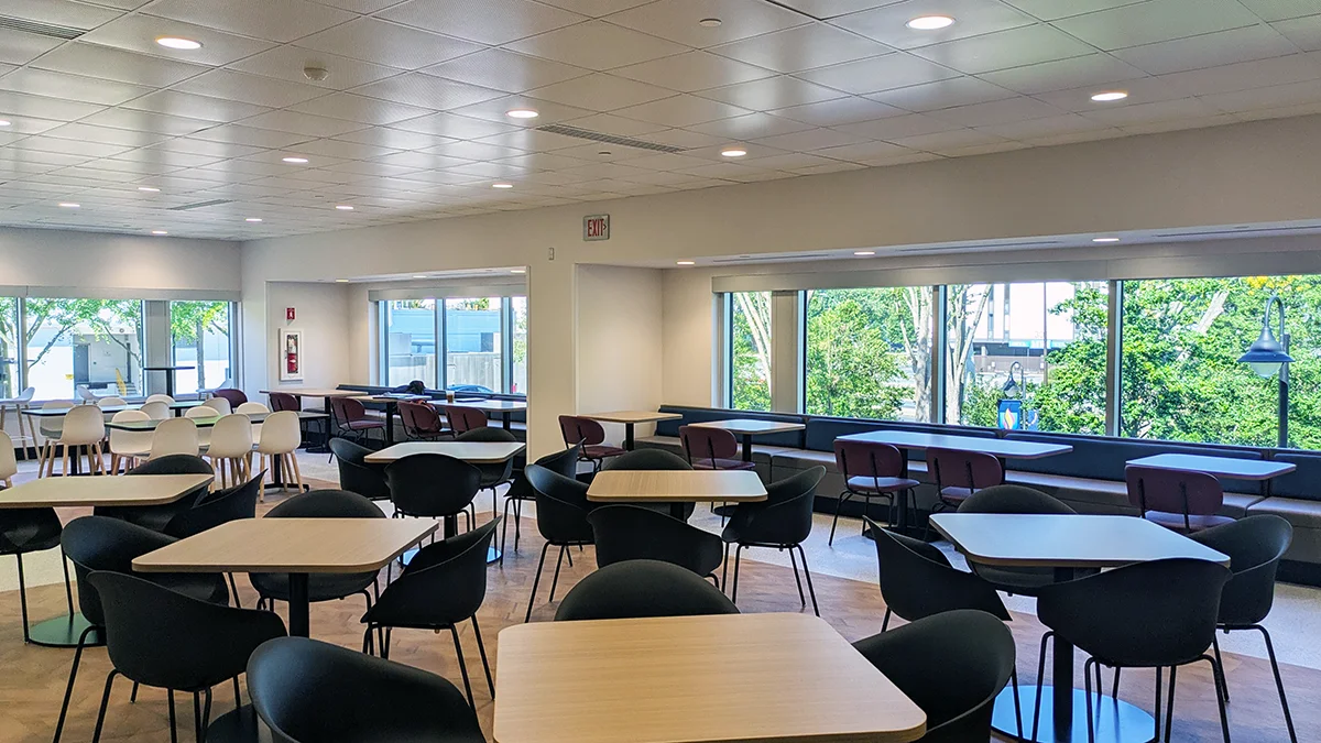 Tables and chairs and windows looking out to campus within the PCOM Dining Commons