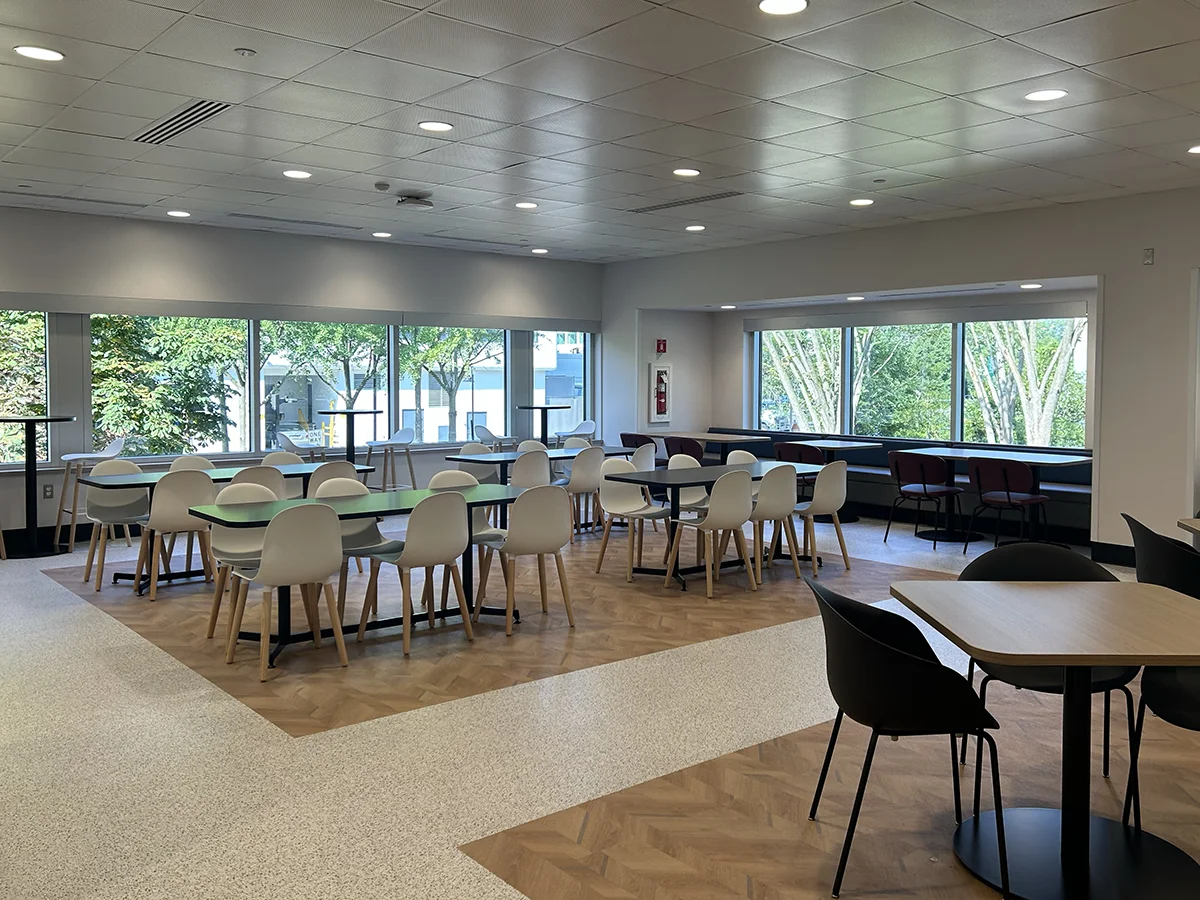 Seating, tables and windows within the dining area of the PCOM Dining Commons