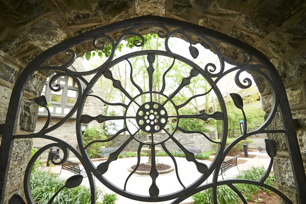 Macro shot of the ornate iron gate along the stone wall of PCOM's Donor Garden