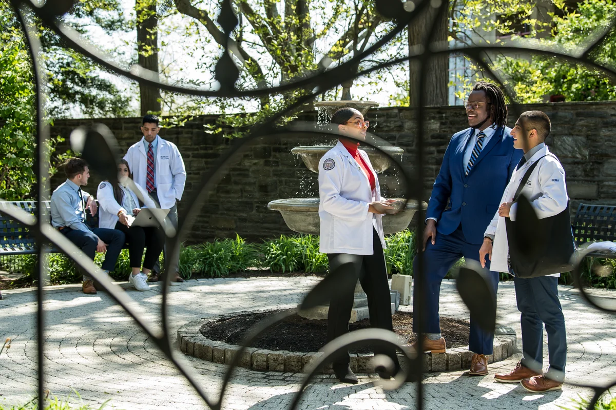Medical students talking around the fountain within the donor garden