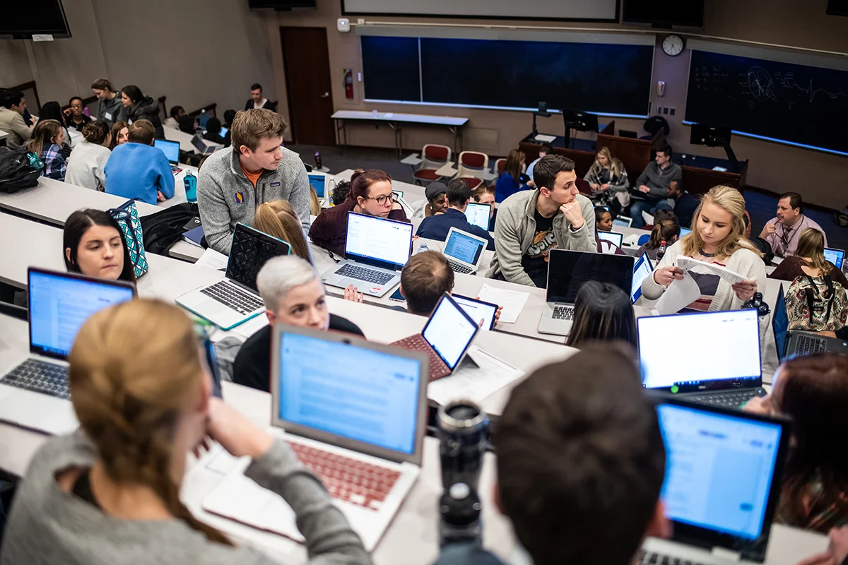 Students talking and working in groups during an IPE exercise in one of PCOM's amphitheaters