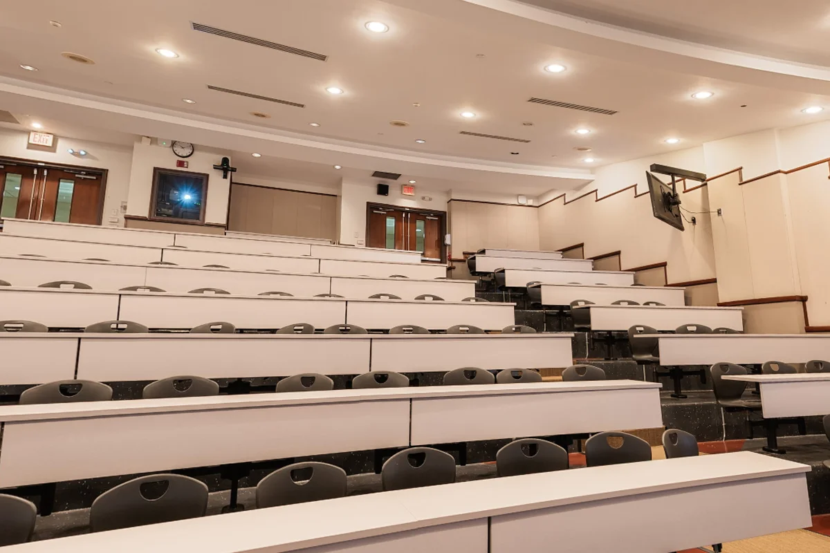 View looking up at rows of tables and chairs in the large lecture hall