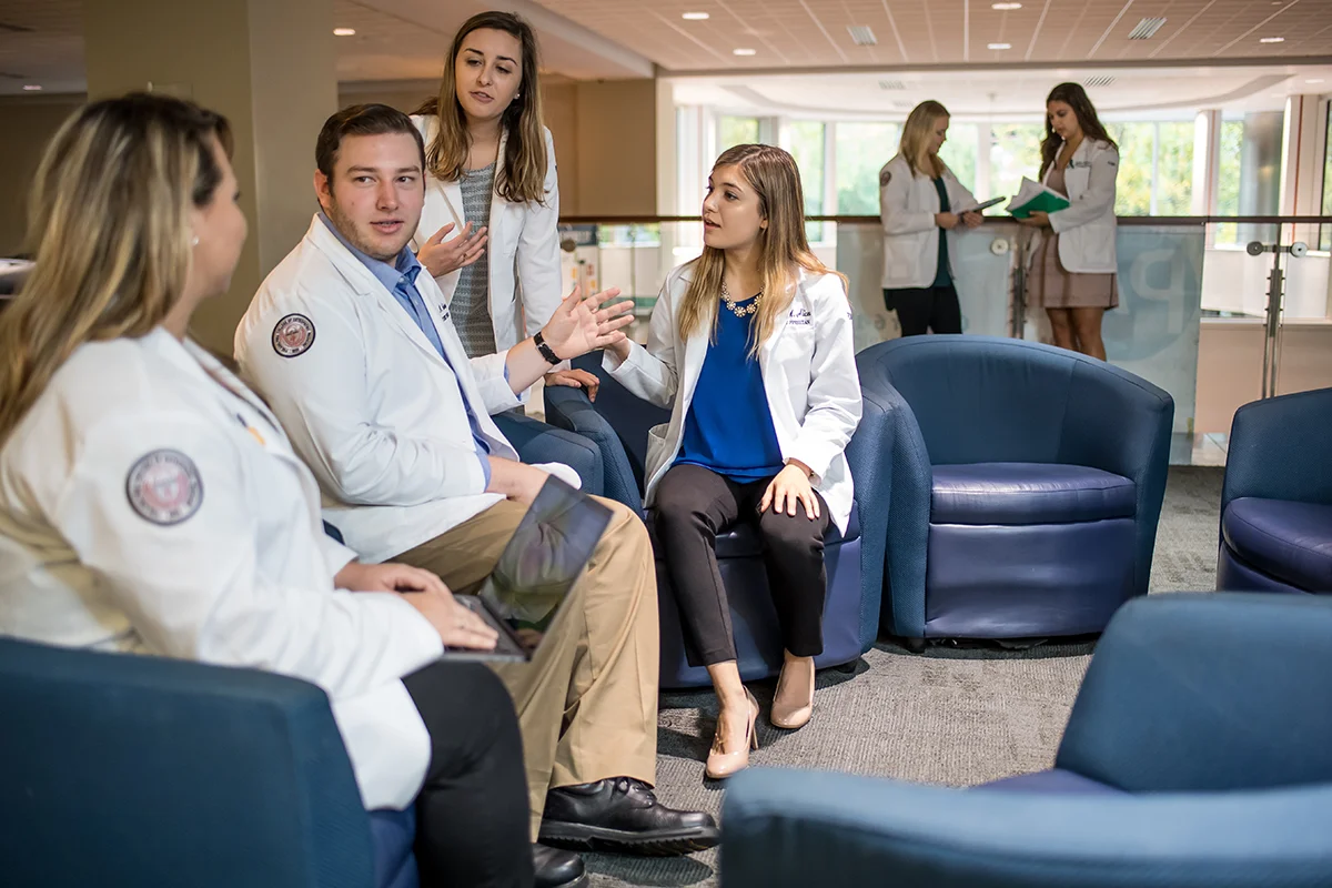 Med students talking in chairs in the upper lobby 
