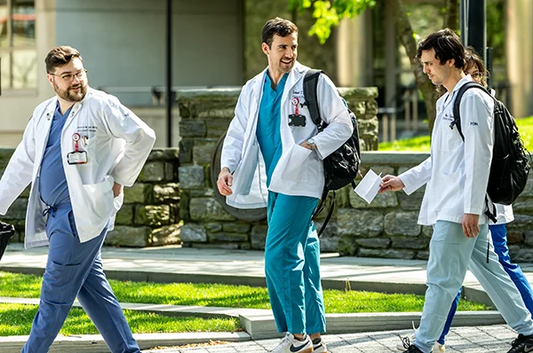 PCOM medical students walking and talking to guests during a campus tour event
