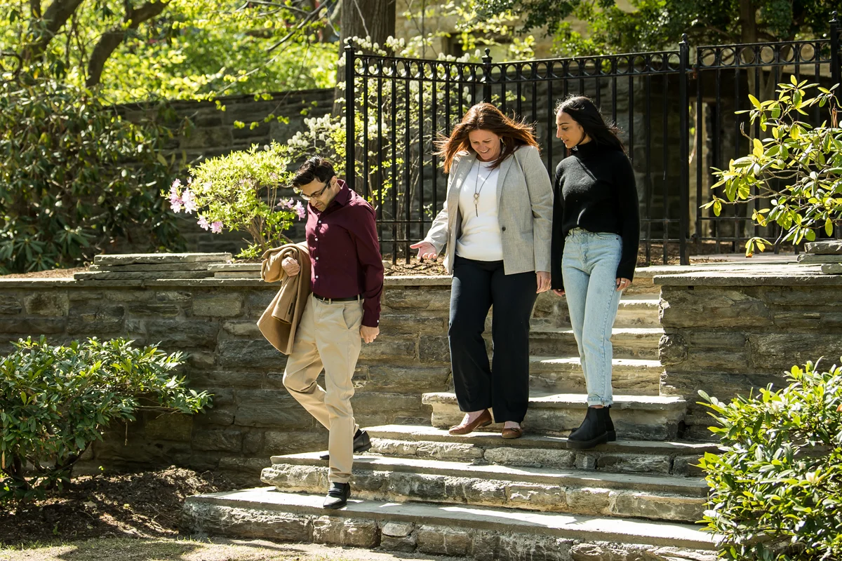 Students and faculty walk and talk as the descend the stone steps behind Levin building