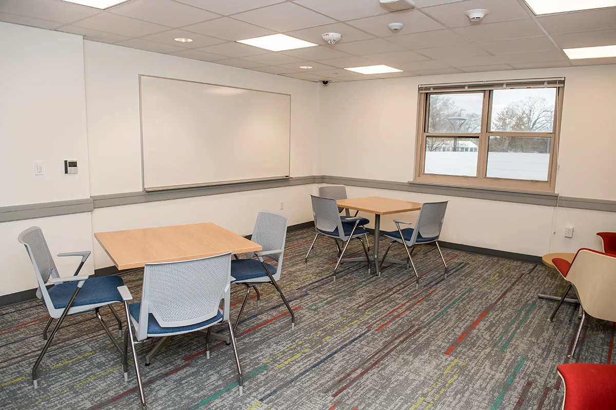 Larger study room with square tables surrounded by chairs
