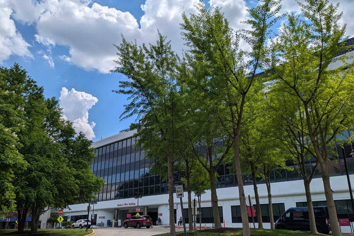 Front view of PCOM's Rowland Hall with trees in front