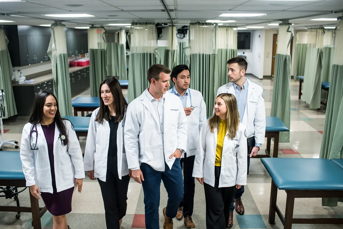 PA Studies students walking and talking in the Physician Assistant Suite